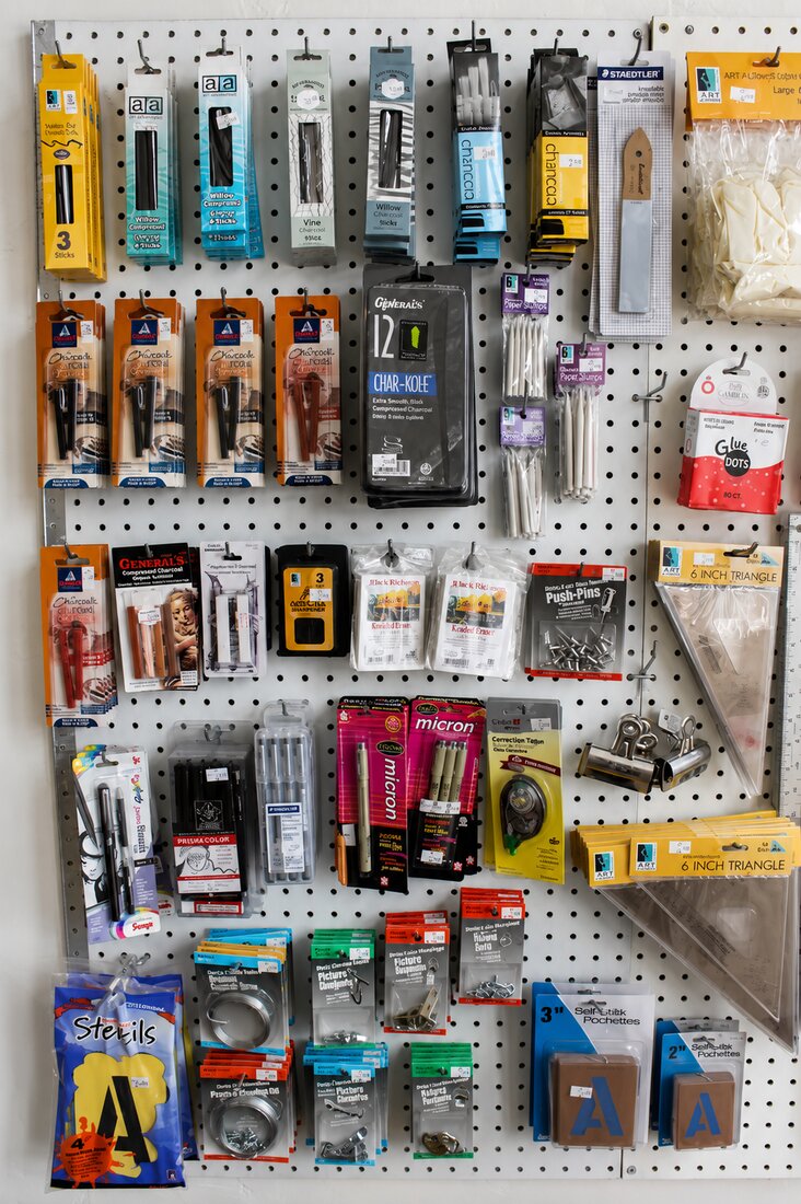A pegboard of charcoal, pencils and drawing tools at VISUAL