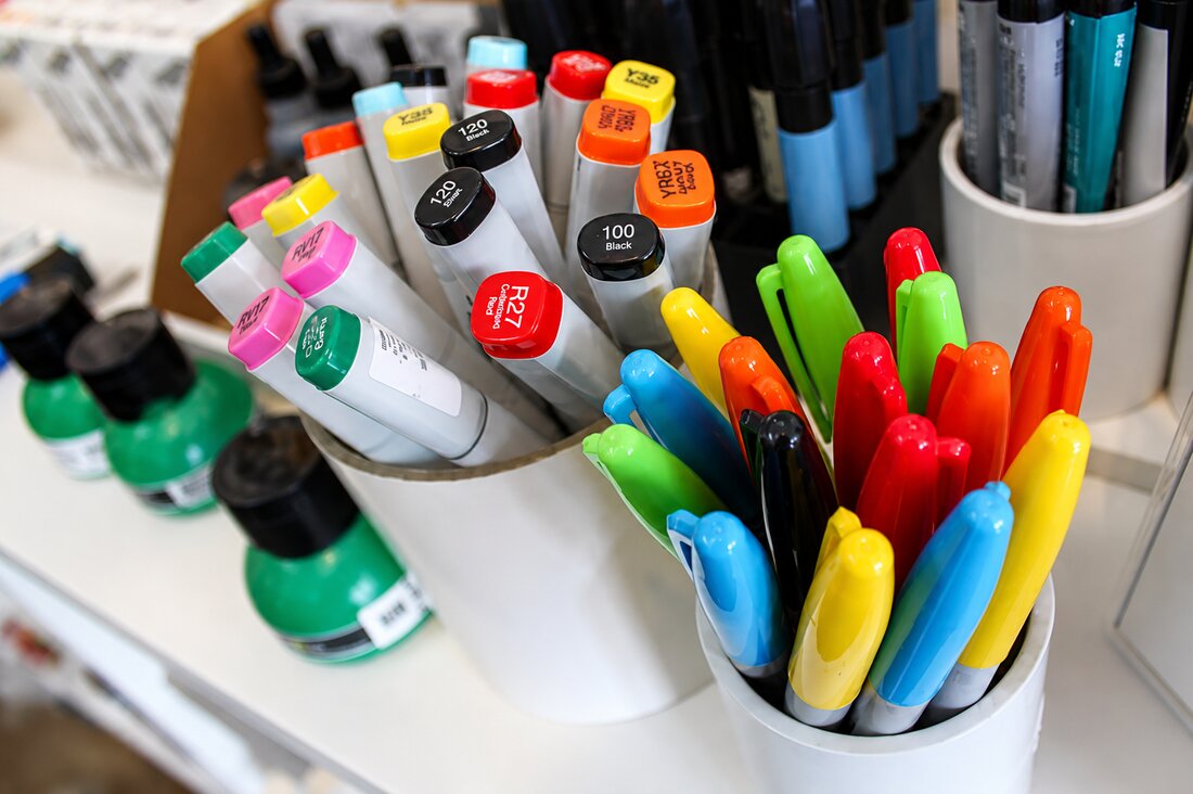 Art markers and brush pens in cups at VISUAL