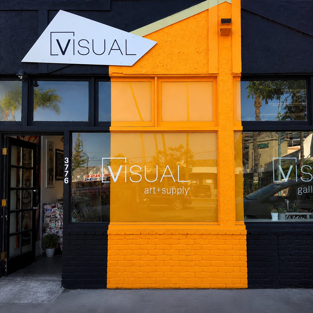 The VISUAL storefront, a black building with an orange panel on 30th Street
